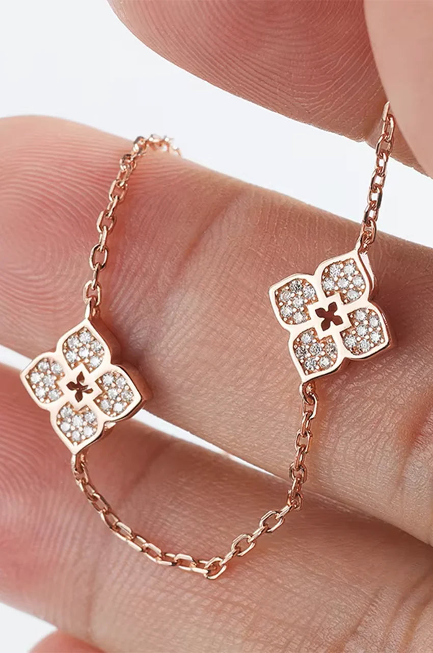 Detail of gold chain links and crystal flower motif held in fingers