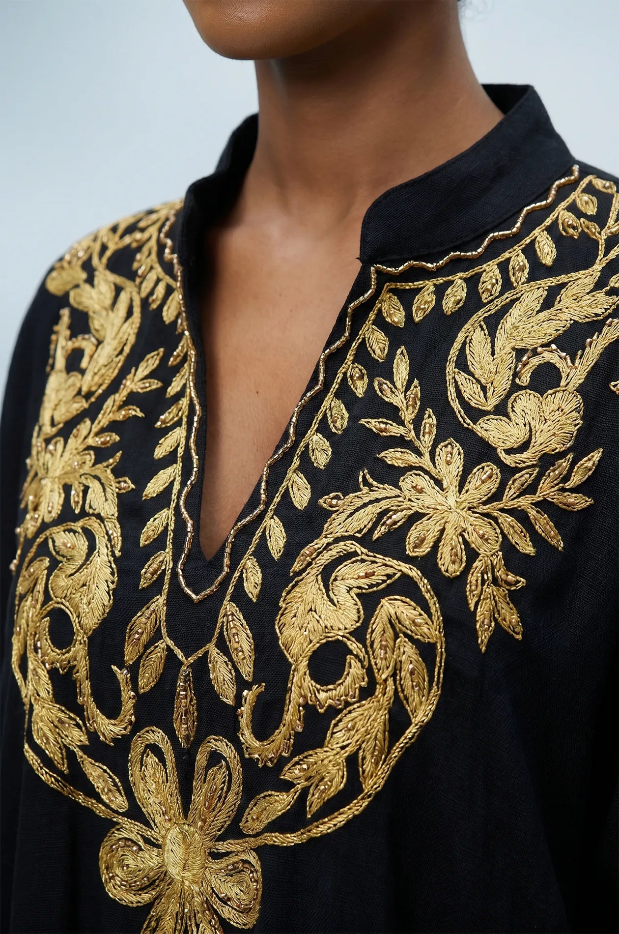 Naylara Halia black kaftan gold floral chest embroidery close-up with model smiling