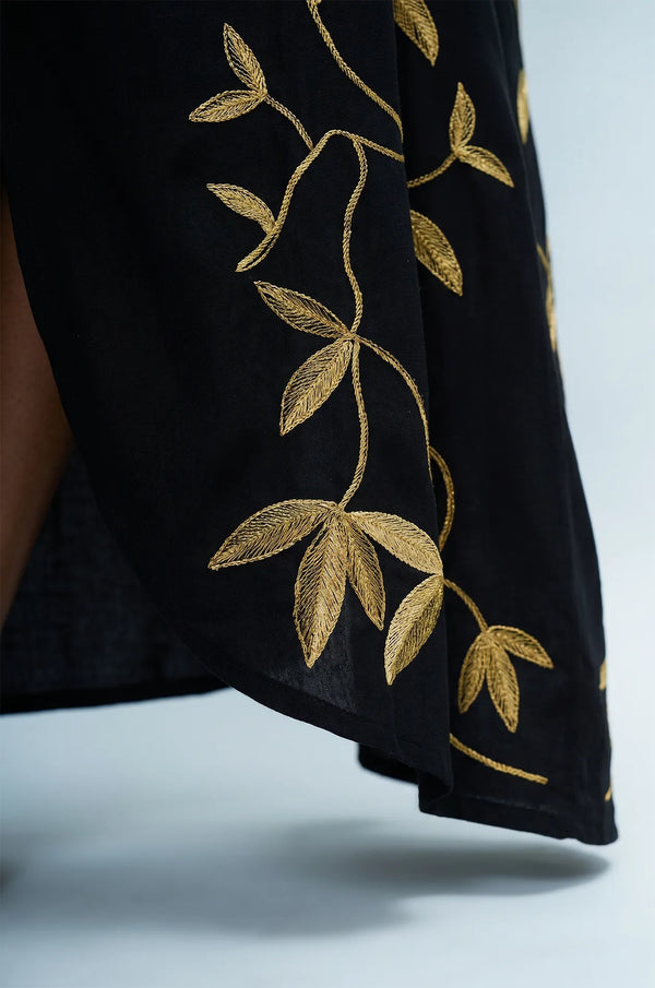 Detail of gold leaf embroidery on hem of Naylara Halia black long kaftan