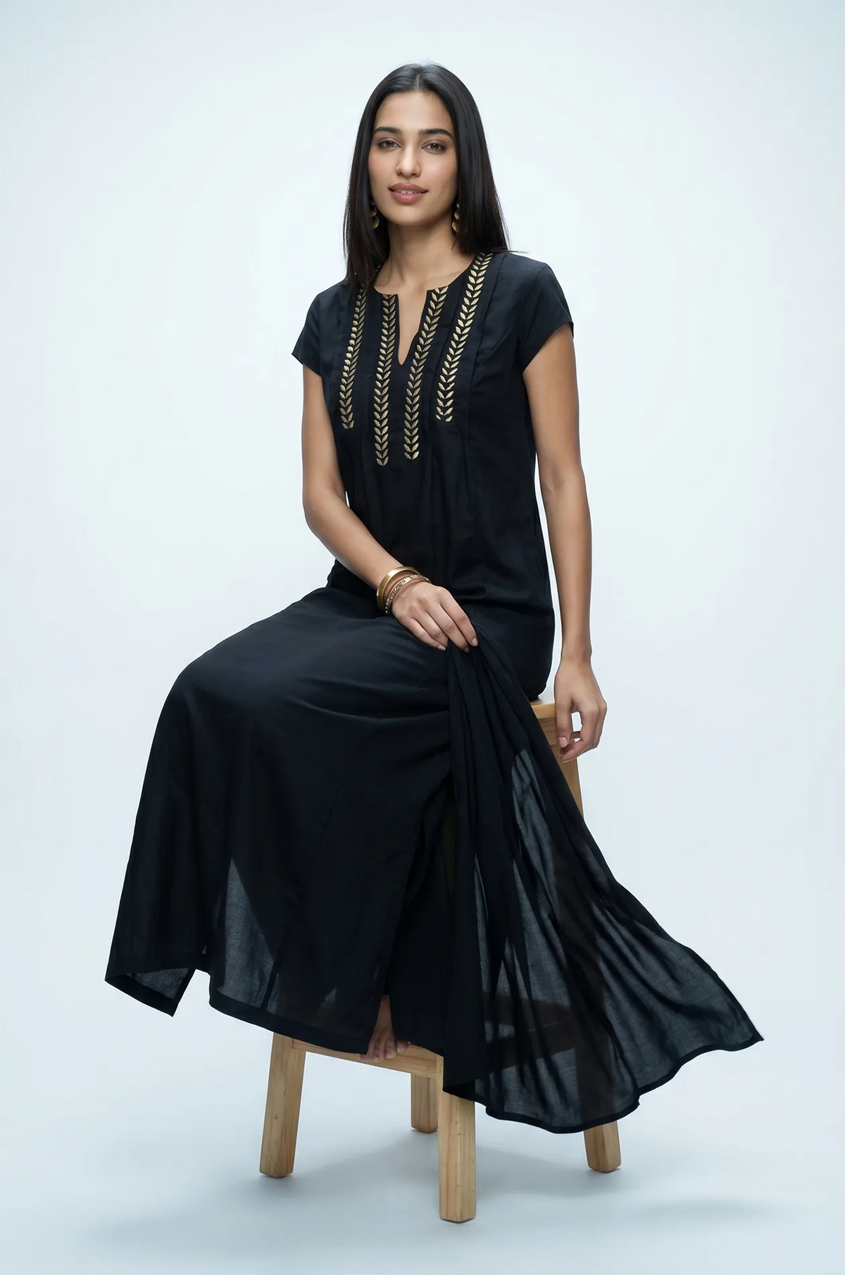Naylara Iara black maxi kaftan with gold embroidery — full length seated studio shot