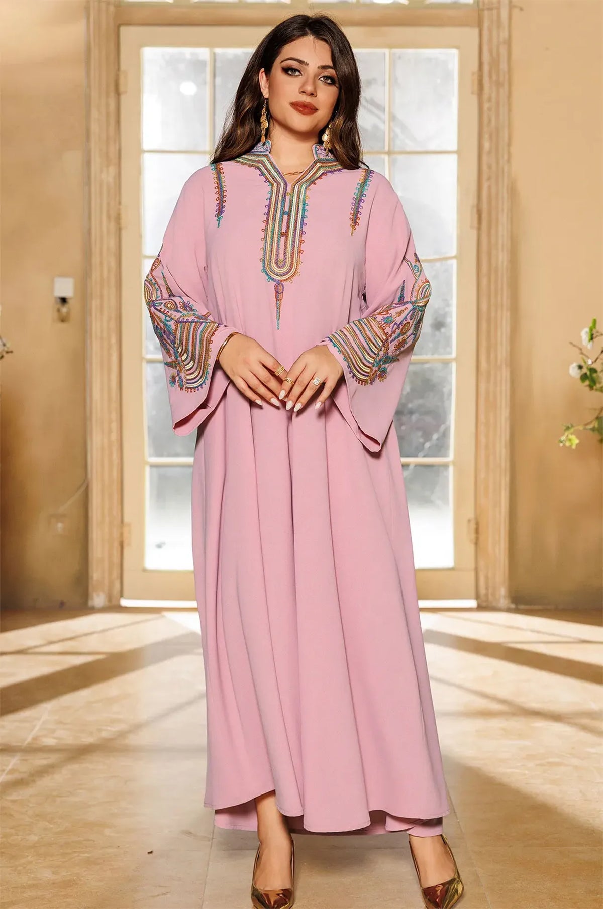 Front view of a model wearing the Inez Pink Jalabiya Kaftan in a sunlit indoor setting, showcasing the full-length silhouette.