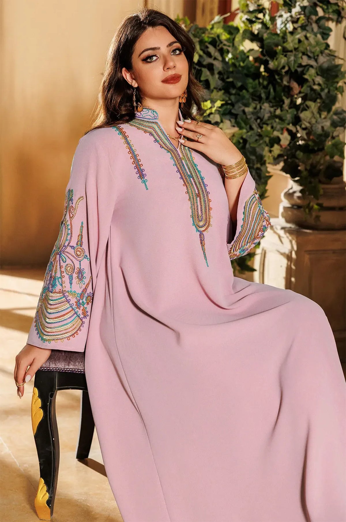 A seated view of the Inez Pink Kaftan showing the intricate details of the bell sleeves and comfortable loose fit.