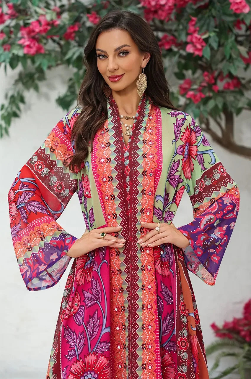 Close-up of the decorative floral vase motifs at the hem of the Kimia orange Indian kaftan night dress from Naylara.