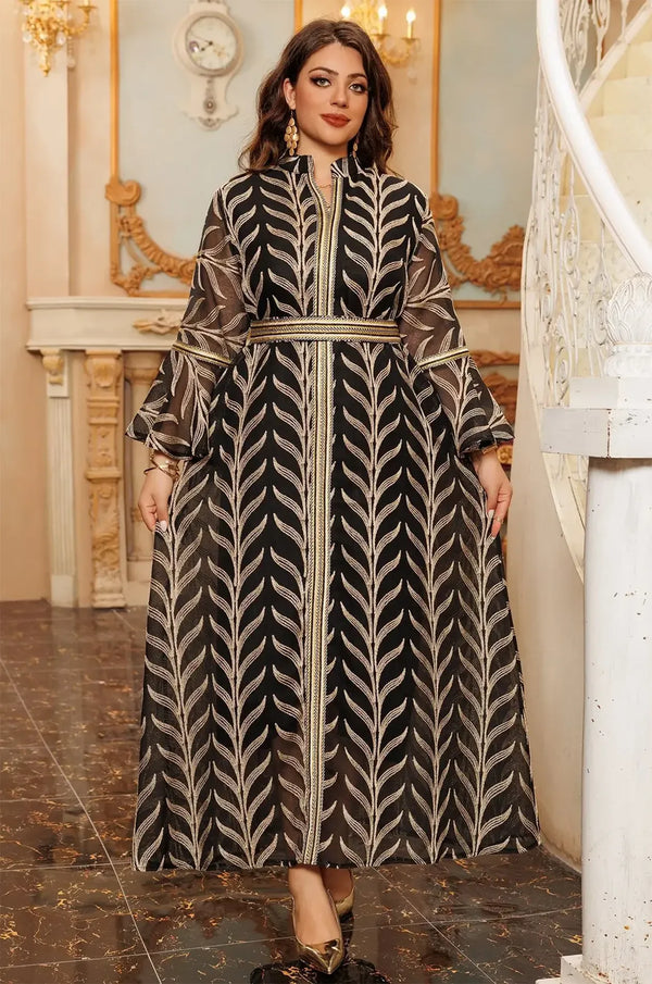 Full-length view of the Kitala Kaftan in black, showing the wide flowing skirt and the consistent metallic leaf embroidery throughout the garment.