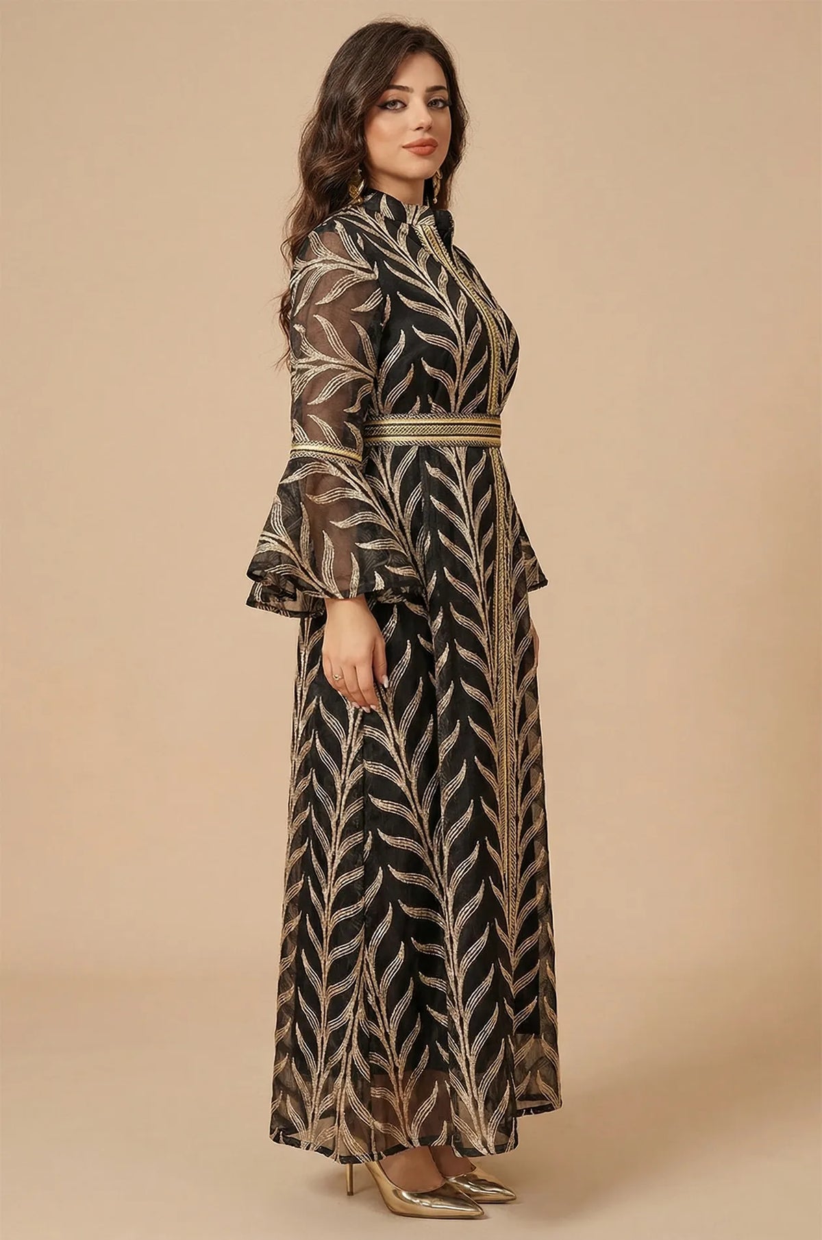 Side profile shot of the black Kitala Kaftan by Naylara, highlighting the sheer fabric drape and the intricate gold embroidered leaf pattern.