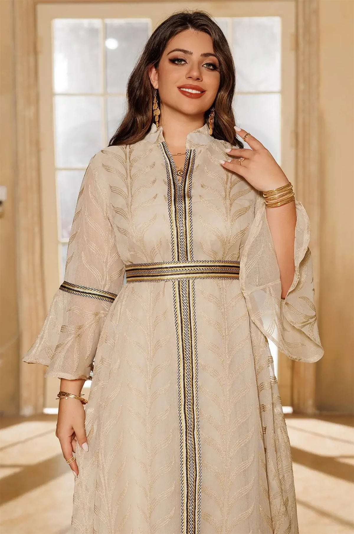 Mid-shot detail of the Kitala Kaftan in ivory beige, focusing on the high stand collar and shimmering metallic gold leaf pattern.