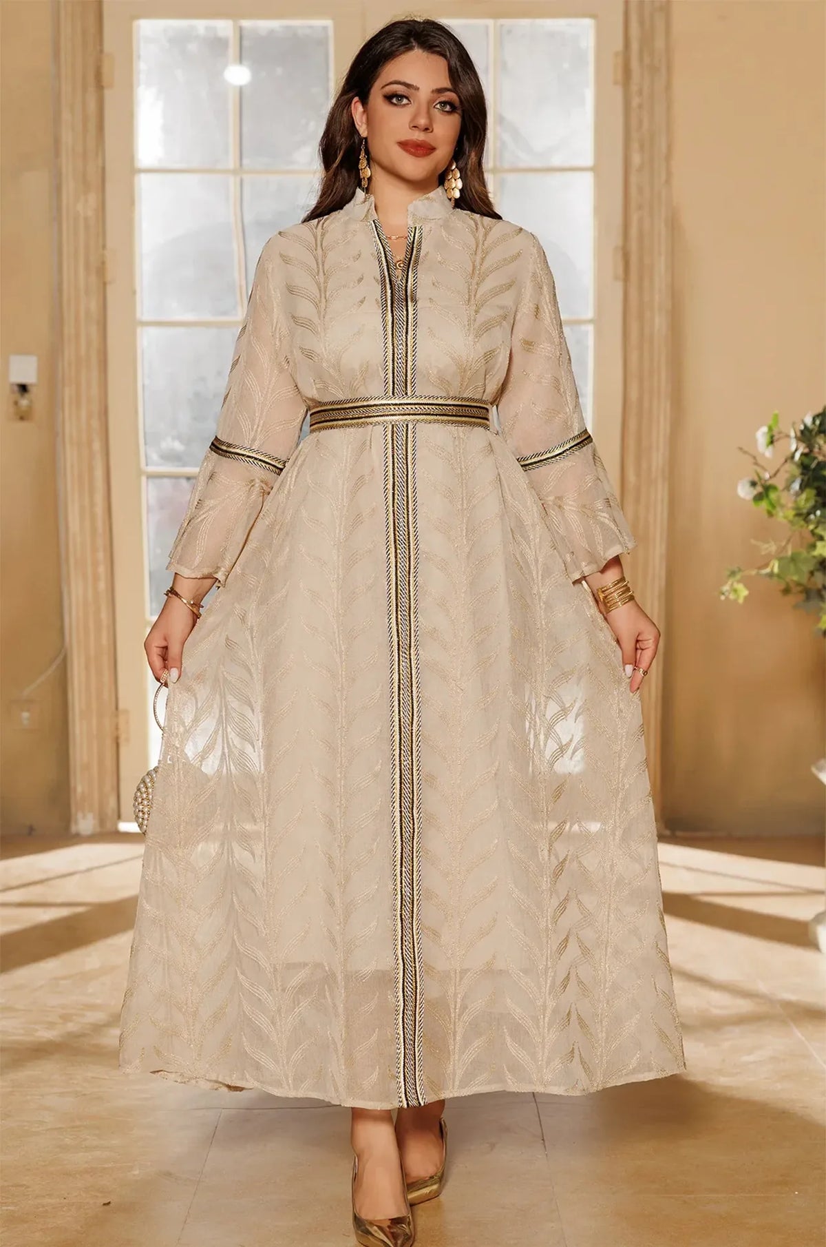 Full-body view of the ivory beige Kitala Kaftan by Naylara, styled with a jeweled gold belt and metallic heels for a formal look.