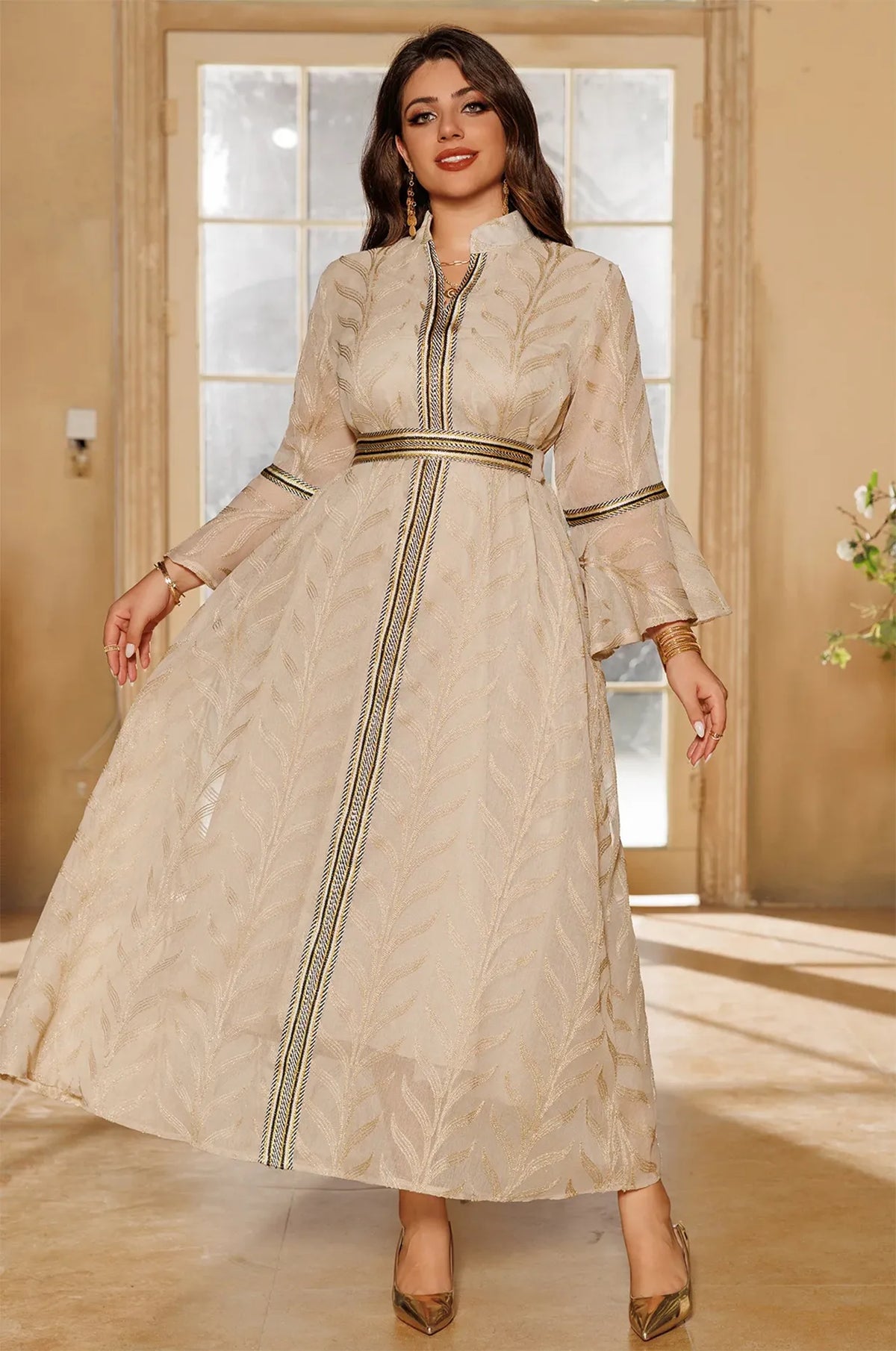 Lifestyle shot of the Kitala Elegant Moroccan Kaftan in ivory beige, showcasing its flowing silhouette and traditional Moroccan design in a sunlit room.