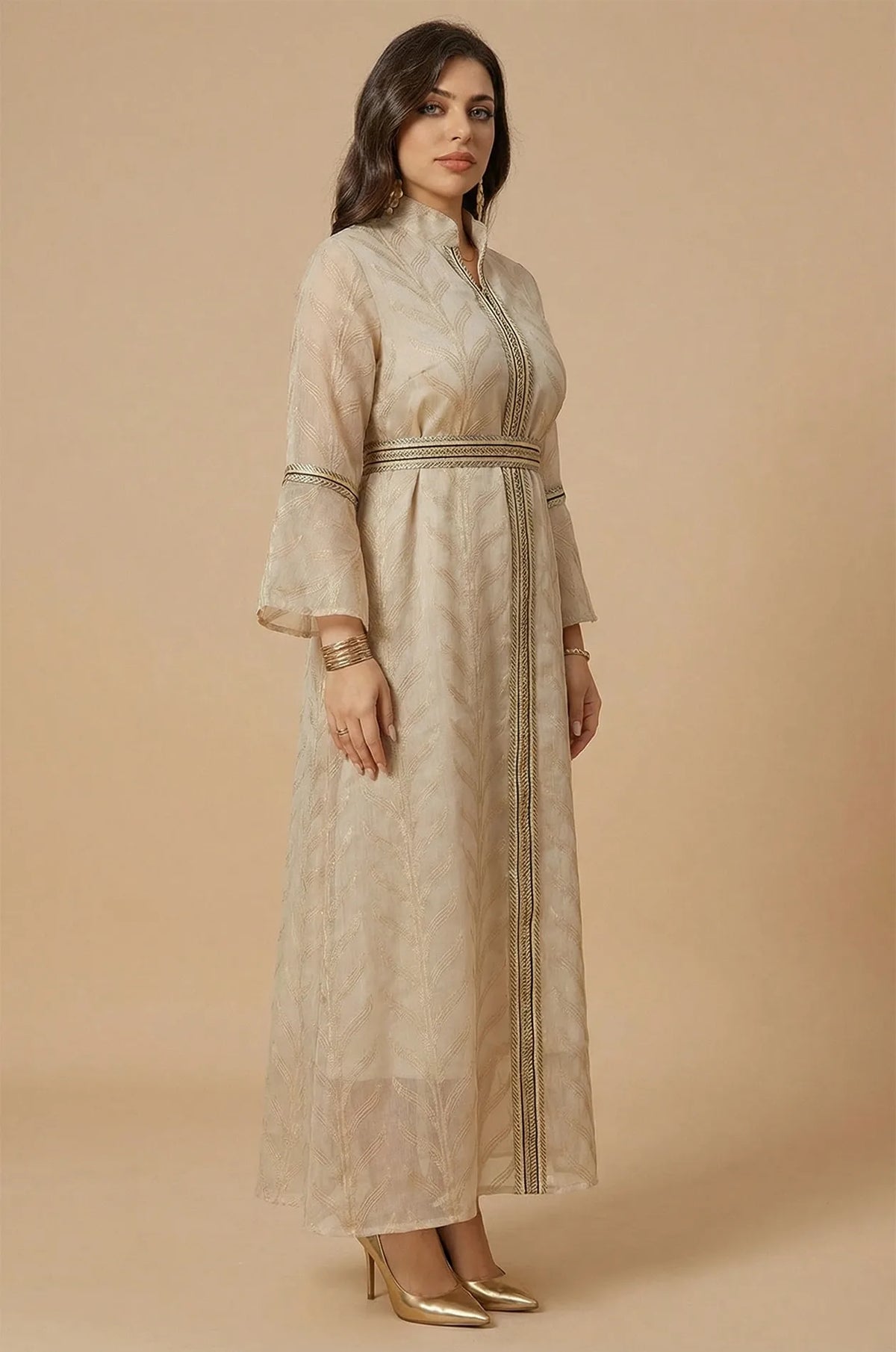 Side profile of a woman wearing the ivory beige Kitala Moroccan Kaftan, highlighting the sheer fabric and elegant gold thread work.