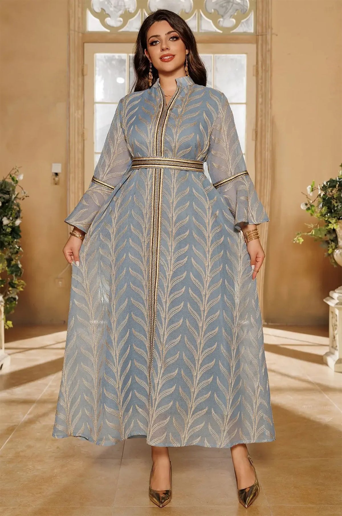 Full-body front view of the light blue Kitala Elegant Moroccan Kaftan in a sunlit luxury room, showcasing the flowing sheer skirt and metallic gold trim.