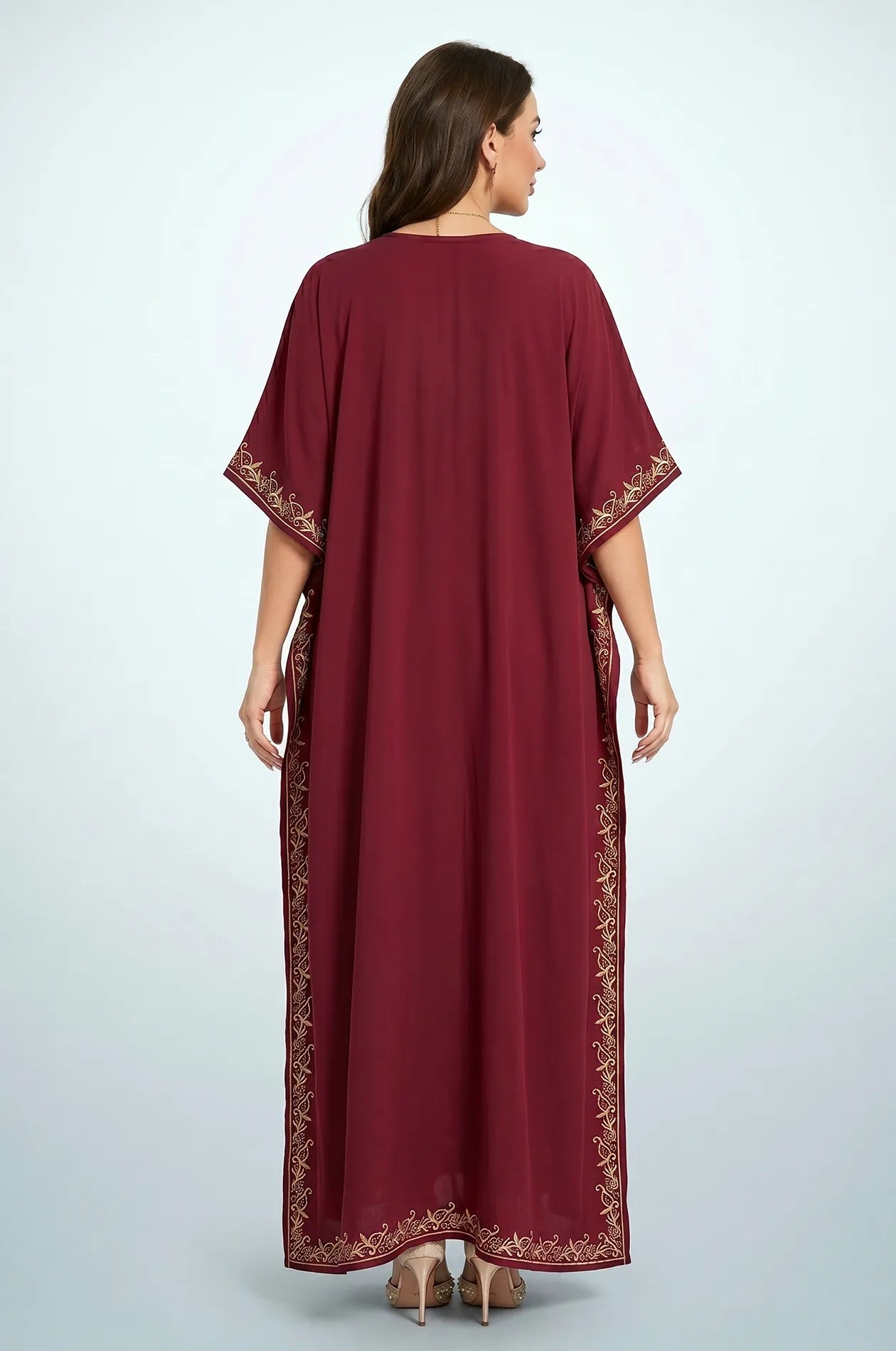 Back view of Naylara Laurel red kaftan showing gold arabesque embroidery border on sides and hem