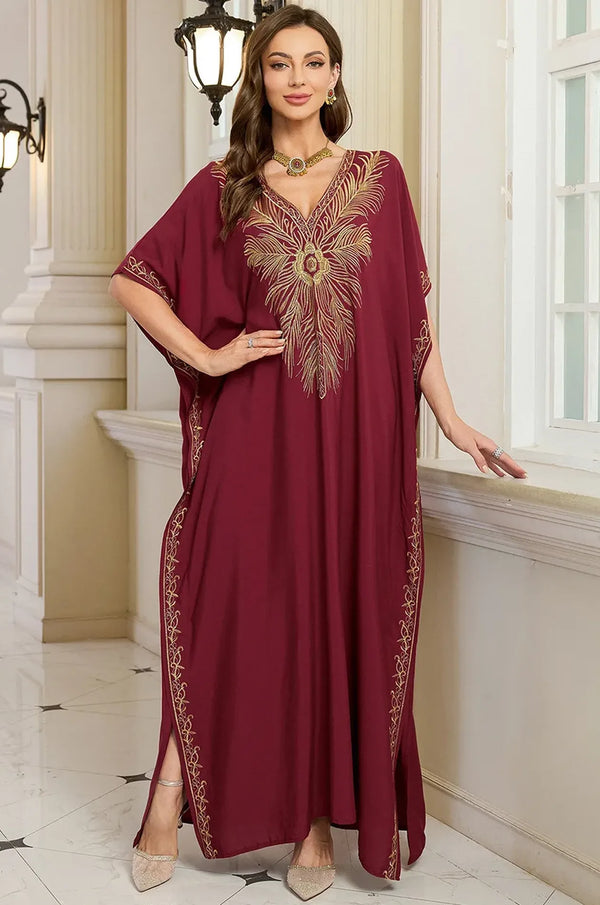 Naylara Laurel red beach kaftan gold feather chest embroidery — hands on hips palace setting