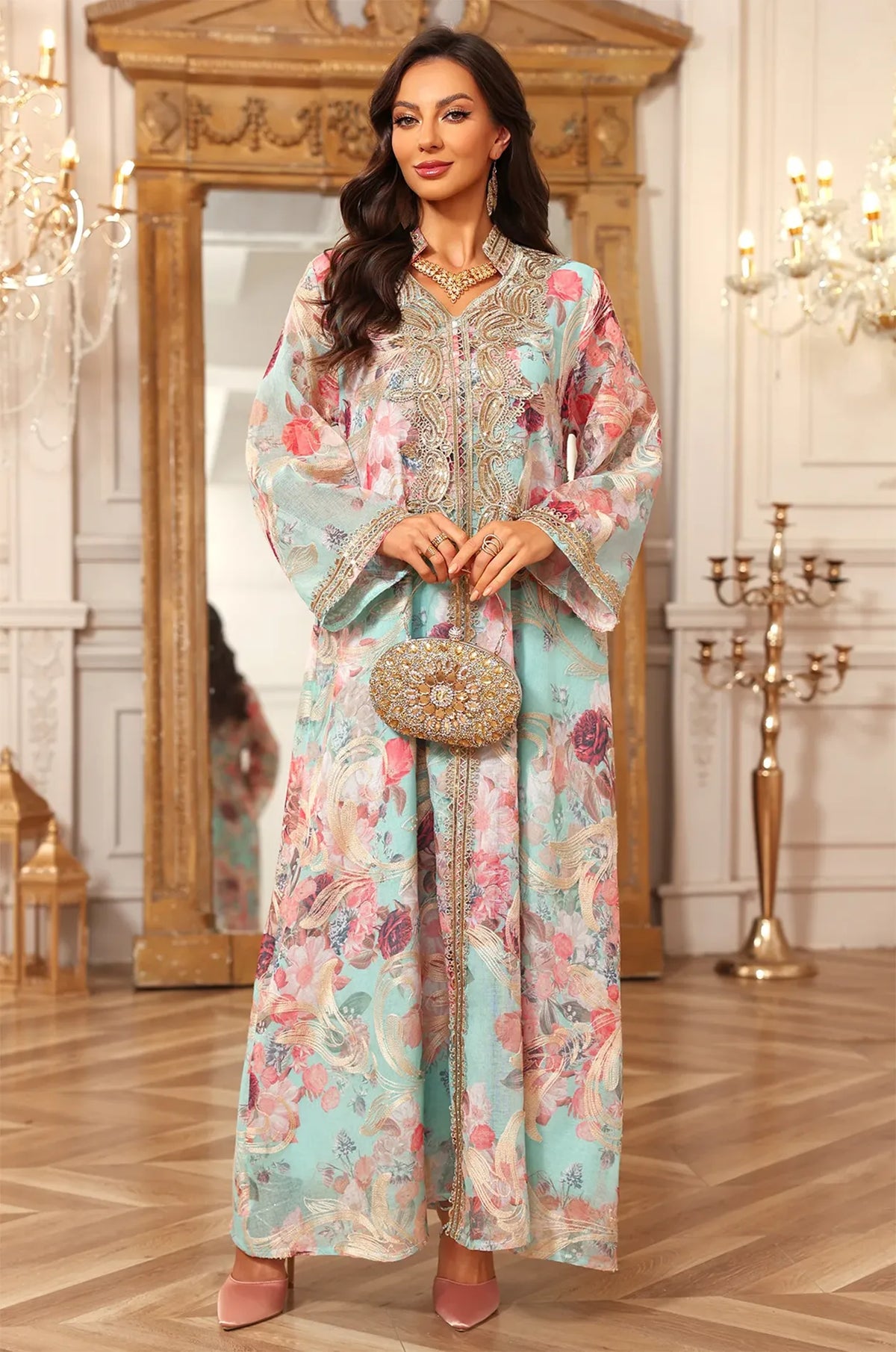 The Lyrae blue kaftan styled for a formal party, featuring an ornate gold clutch and matching accessories.
