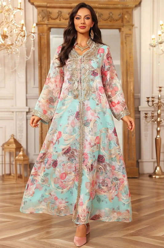 A full-length dynamic view of the blue Lyrae kaftan emphasizing the vibrant rose print and lightweight silhouette.