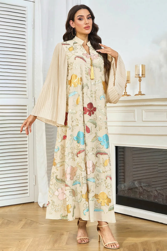 Elegant lifestyle shot of the Marylin Beige Kaftan by Naylara, featuring the V-neckline and signature gold tassel ornament.