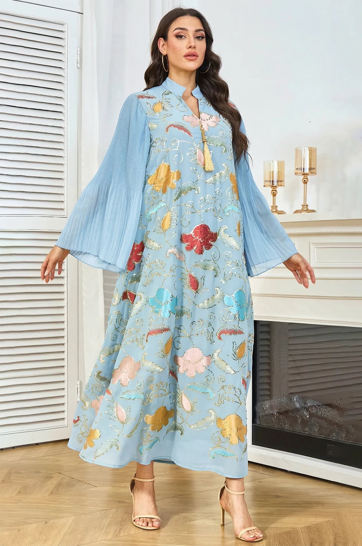 Front view of the Marylin Light Blue Kaftan with arms extended, displaying the volume and fluid movement of the pleated sleeves.