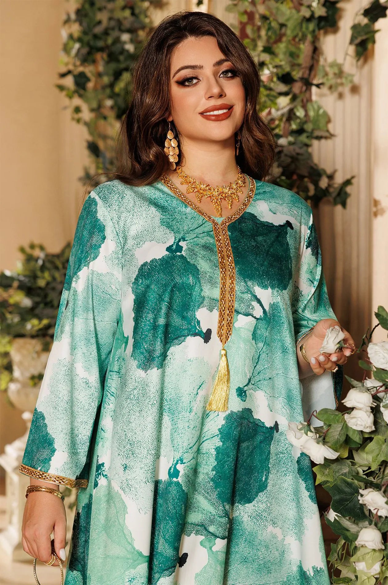 Close-up of the intricate gold sfifa braided trim and tassel detail on the green Navae tropical print kaftan.