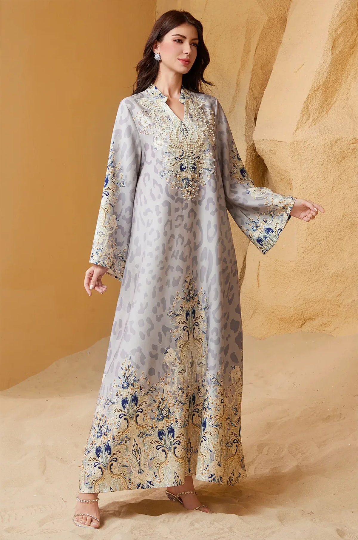 The Nyx Gray Animal Print Kaftan featured in a desert setting, showing the contrast between the gray leopard pattern and the vibrant blue paisley border prints.