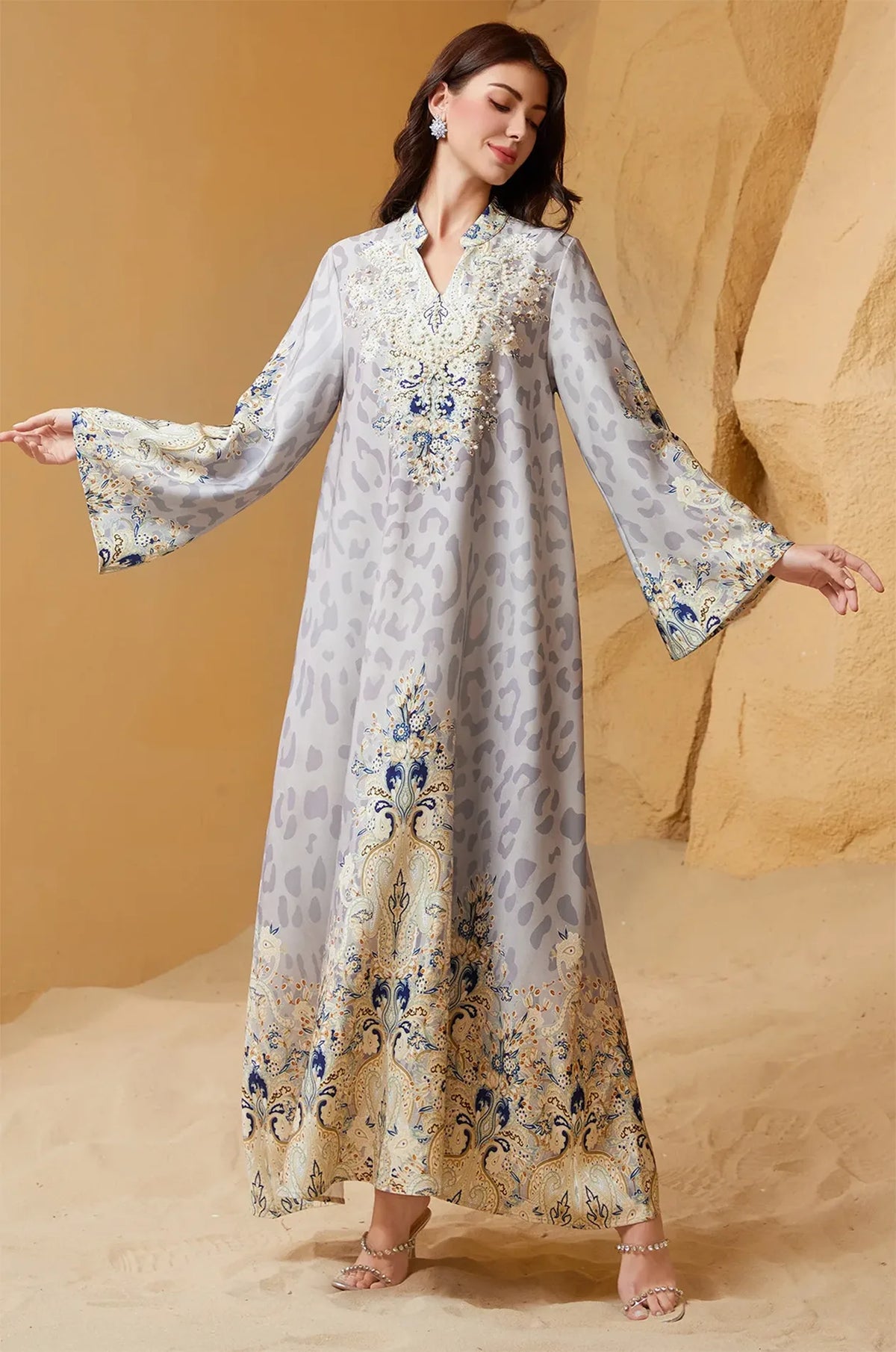 Model posing with arms wide to show the butterfly-style bell sleeves and the expansive flowy fit of the Nyx Gray Animal Print Kaftan.