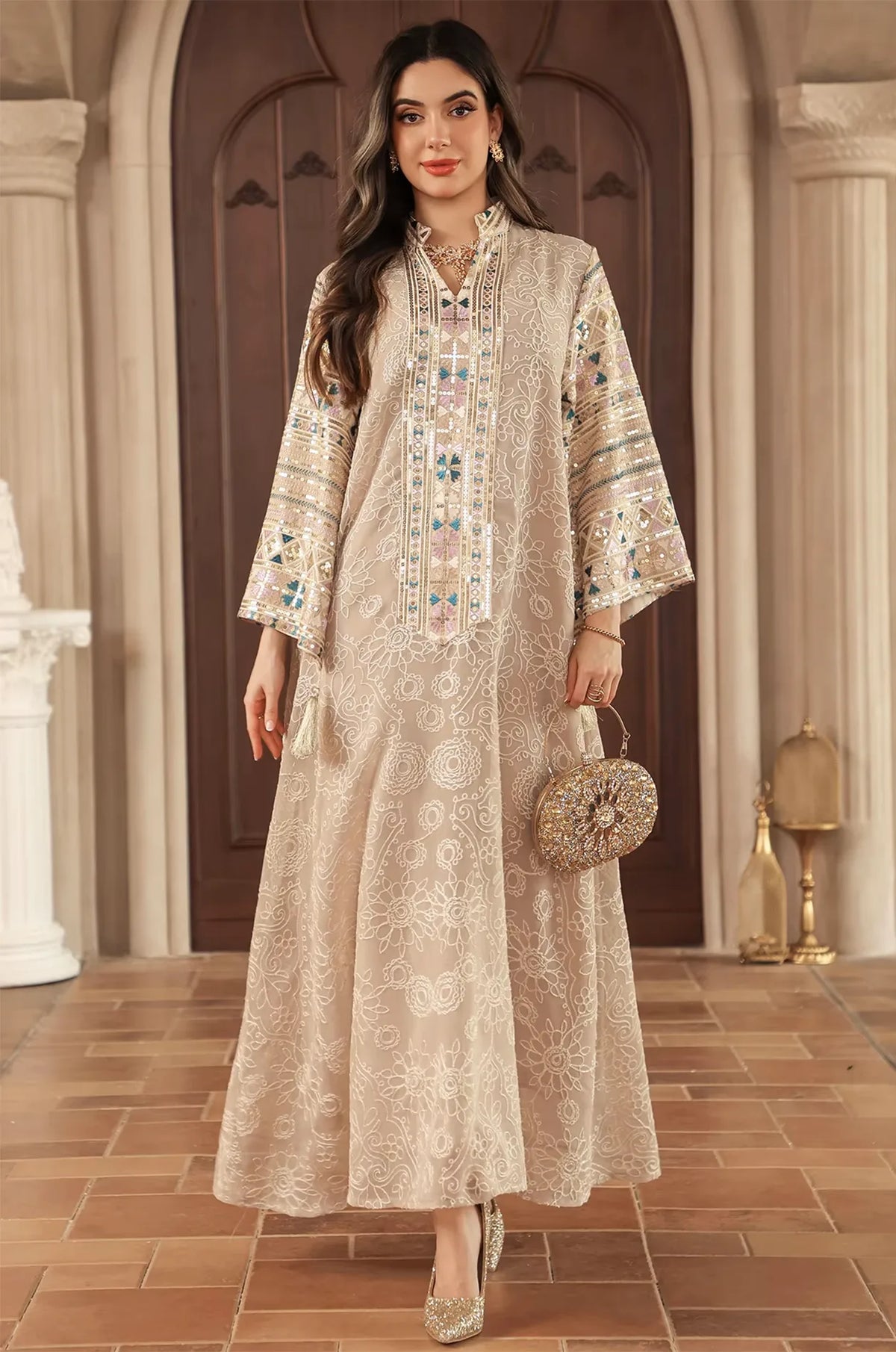 Elegant indoor lifestyle shot of the Orla apricot beige bell sleeve kaftan with metallic sequin accents.