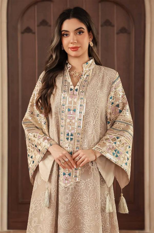 Detailed shot of the intricate white floral embroidery and sequined borders on the apricot beige Orla kaftan.