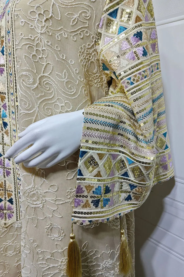 Macro detail of the Orla apricot beige kaftan sleeve featuring metallic geometric sequins and tassels.