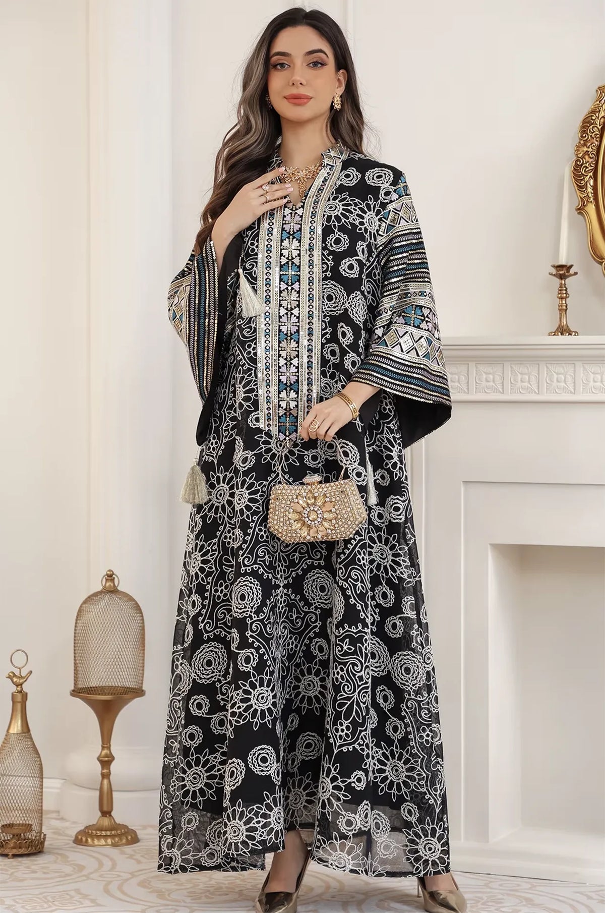 Formal styling of the Orla black bell sleeve kaftan paired with a gold embellished clutch and jewelry for a gala event.