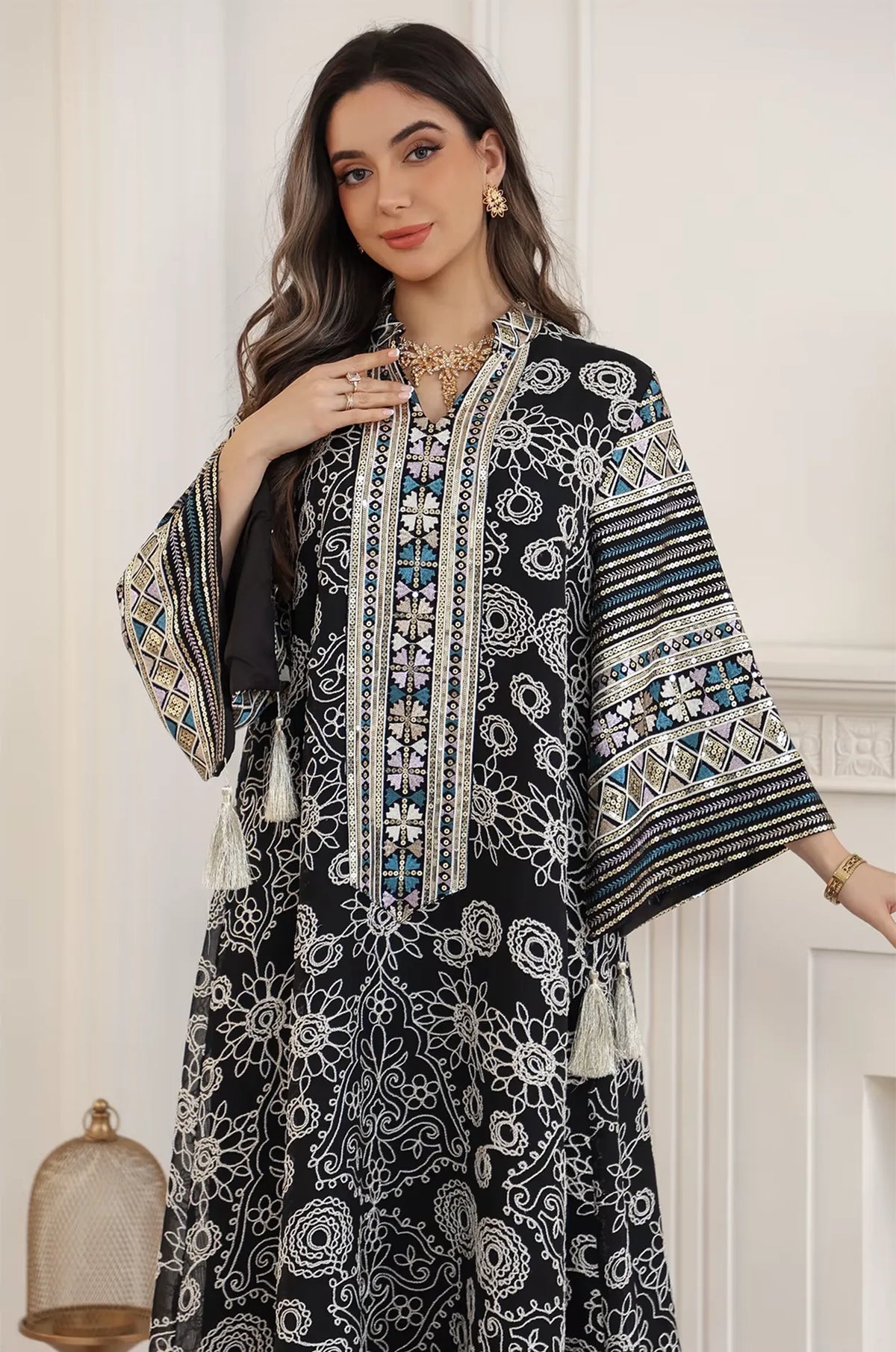 Close-up front view of the Naylara Orla black bell sleeve kaftan featuring intricate white floral embroidery and a sequined V-neckline.