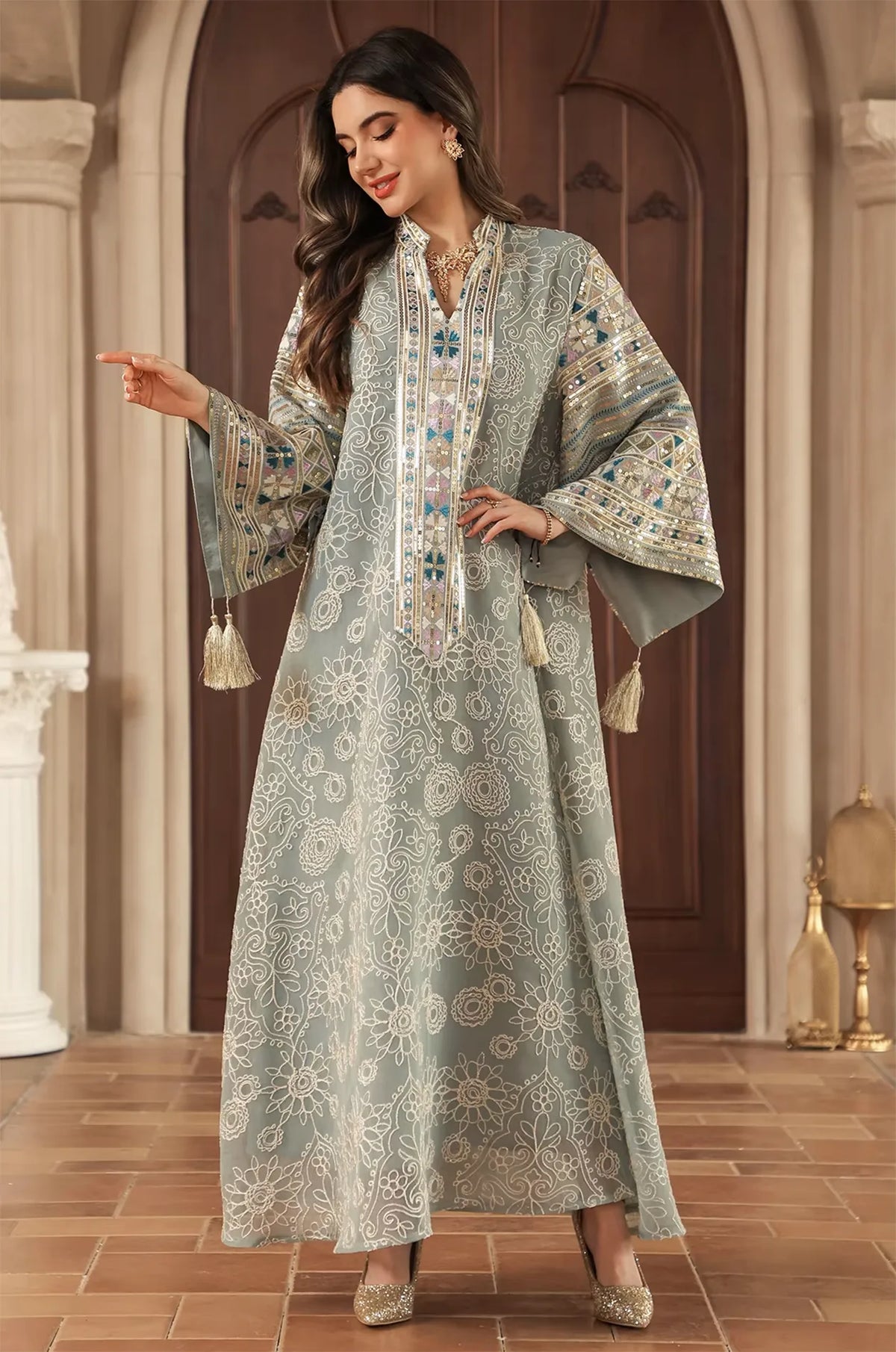 Model posing in the Orla light green bell sleeve kaftan showcasing the dynamic movement of the tassel accents.