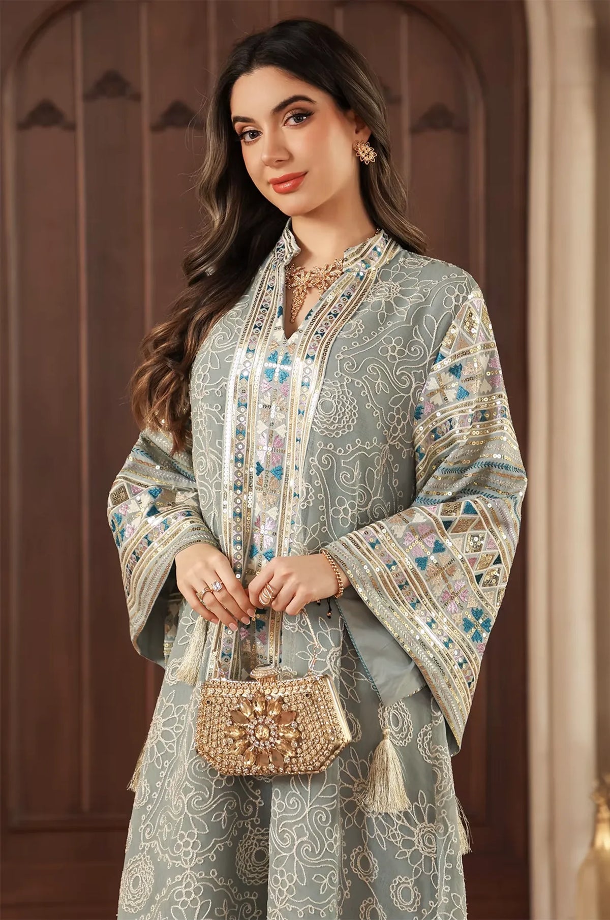 Elegant styling of the Orla light green bell sleeve kaftan with a gold beaded clutch and V-neck sequin detail.