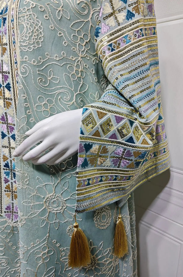Extreme close-up of the Orla light green kaftan sleeve featuring metallic sequins, geometric lace, and silk tassels.