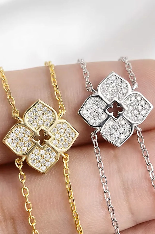 Close up detail of pave setting on four-petal flower pendant in gold and silver