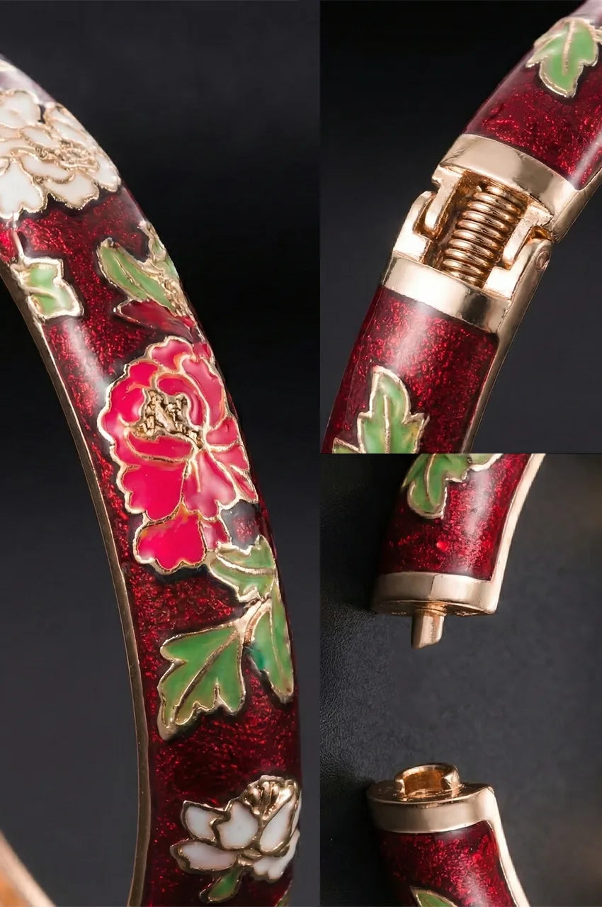Close up of the gold hinge mechanism and floral texture on red enamel bangle.
