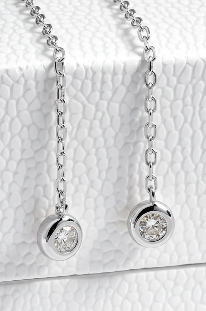 Macro shot of silver chain ends with round bezel set moissanite stones