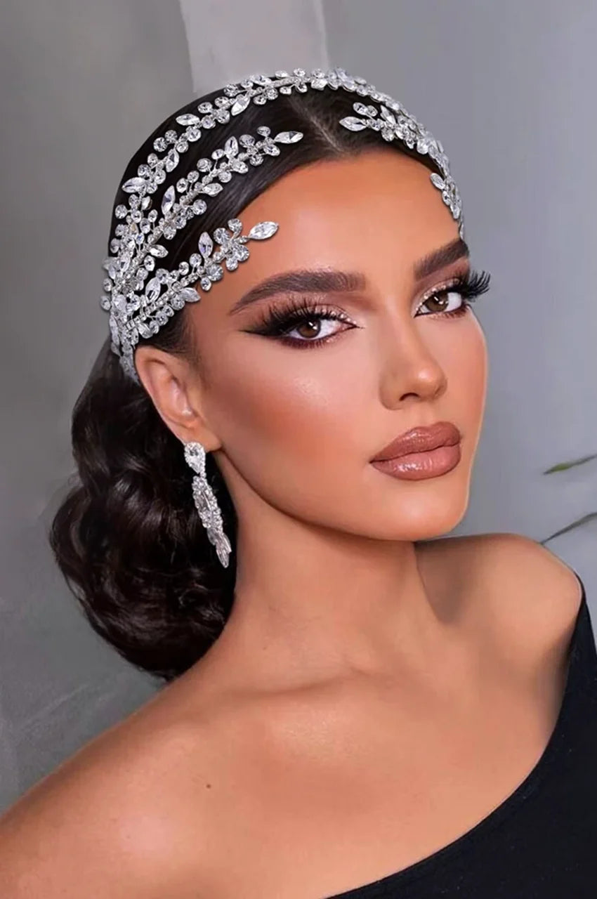 Woman wearing Silver-Tone Crystal Bridal Headpiece with intricate rhinestone leaf design and elegant low hairstyle, styled for a formal event or Caftan accessory.