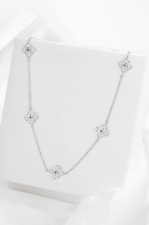 Silver moissanite flower necklace displayed on white presentation box