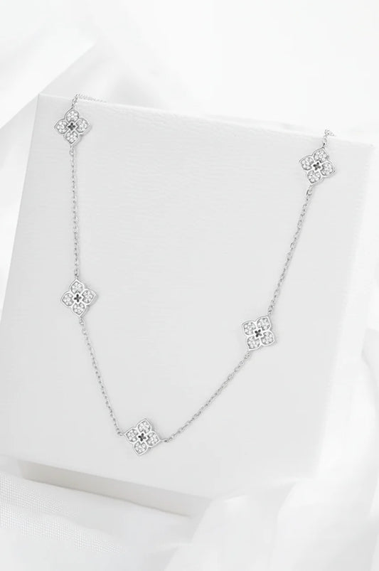 Silver moissanite flower necklace displayed on white presentation box