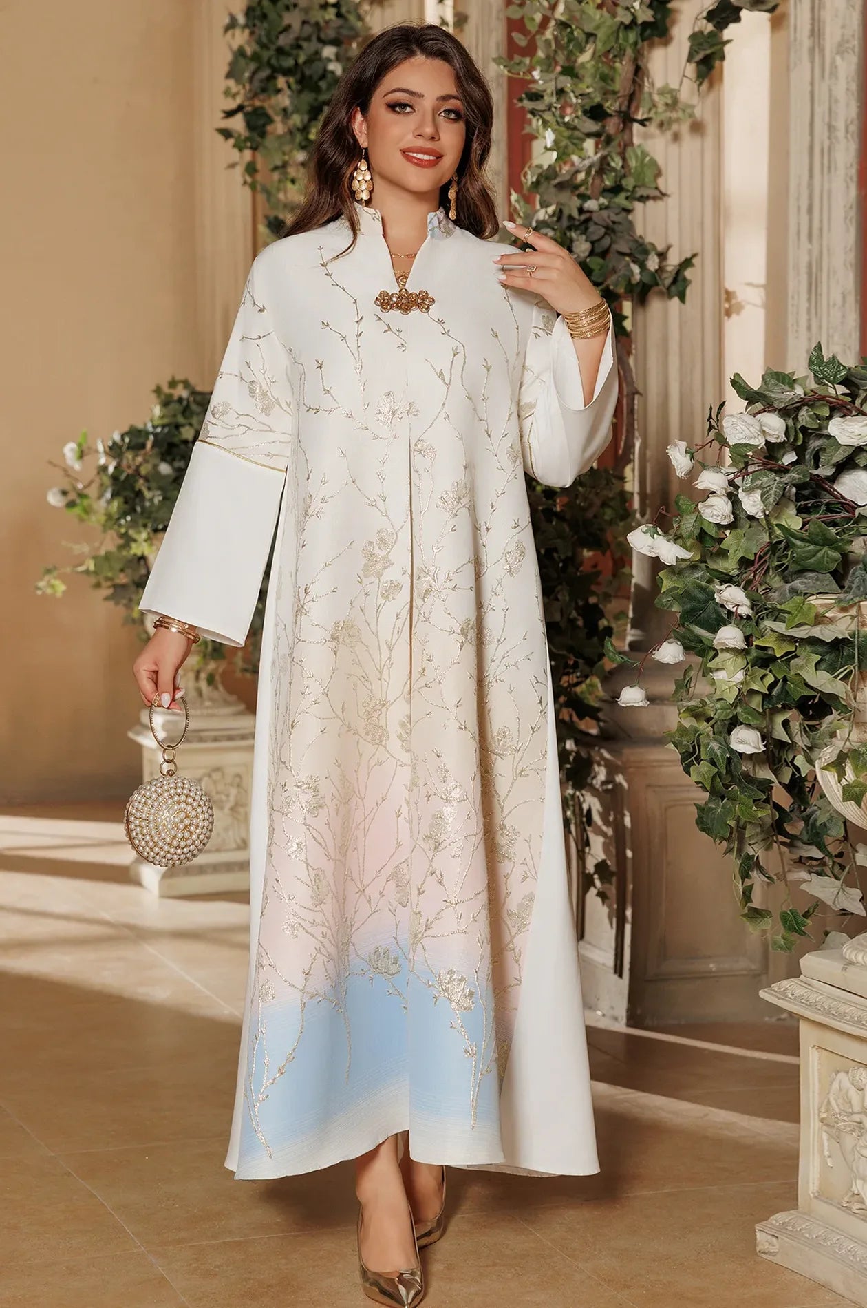 Full-length view of the Light Blue Tayla Botanical Kaftan styled with a luxury pearl bag, perfect for a wedding or formal event.
