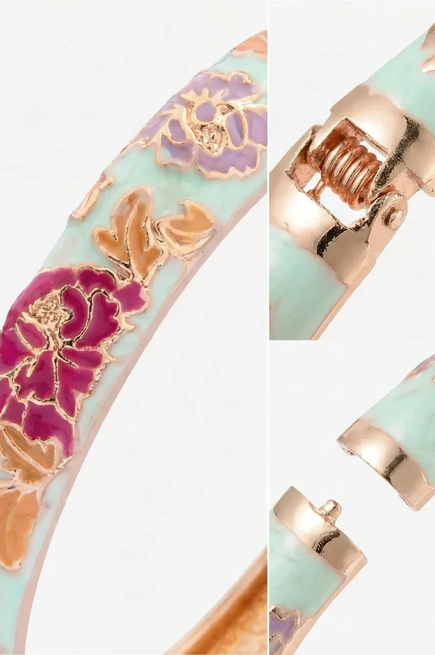 Macro shot of spring hinge and gold details on white floral enamel bracelet.