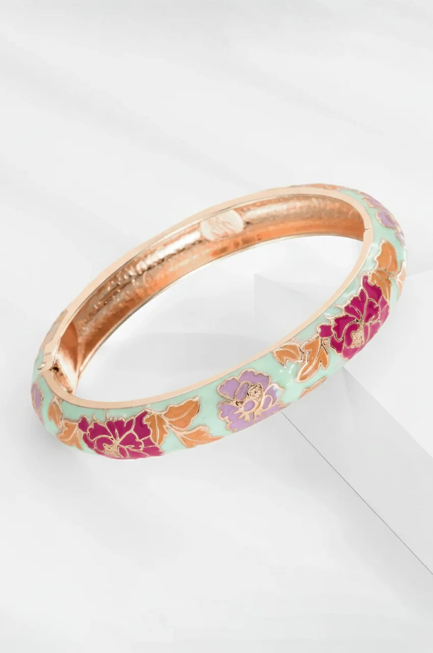Elegant white enamel gold hinged bracelet with magenta flowers.