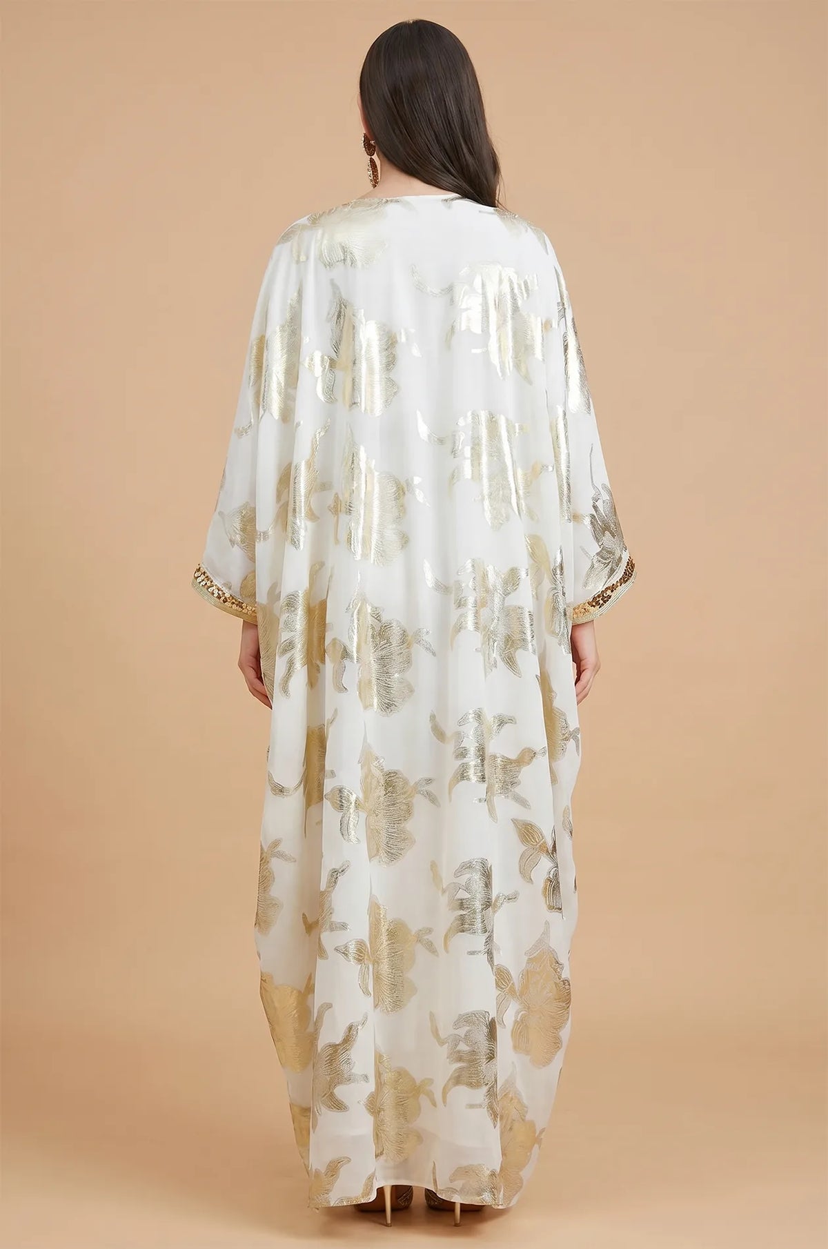 The back view of the white Puppis luxe kaftan showing the elegant drape of the gold floral printed cape overlay.