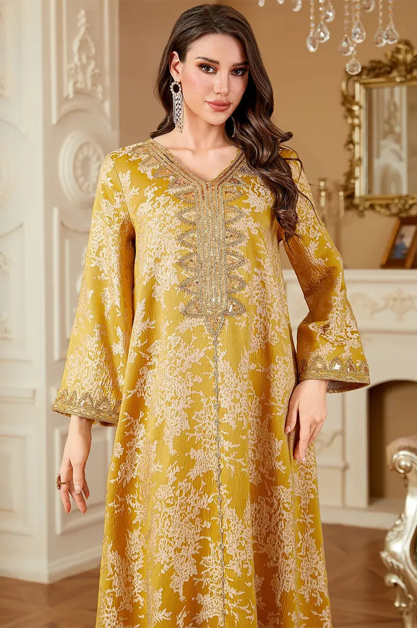 Close-up detail of hand-embellished sequin V-neckline on Zafra mustard yellow kaftan.