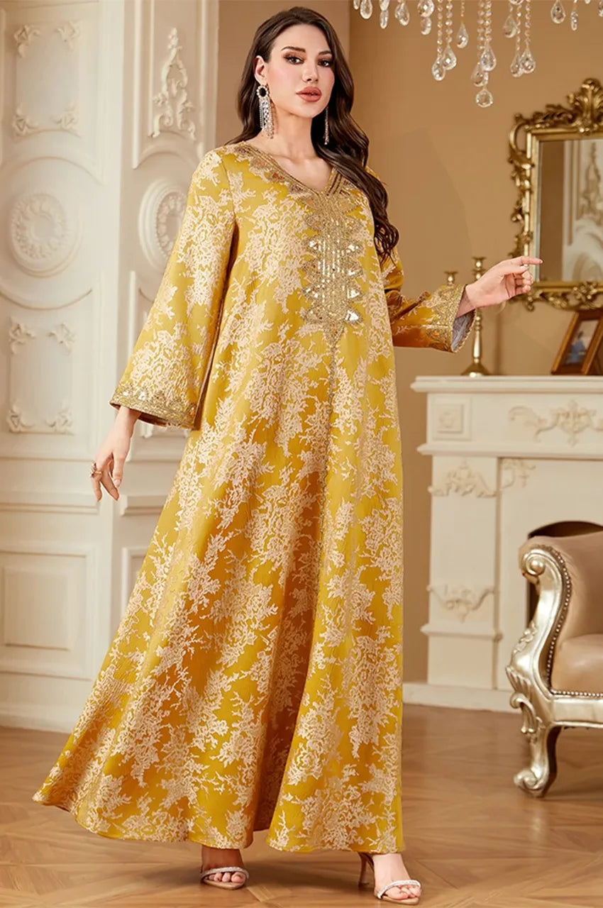 Model walking in Zafra embellished mustard yellow kaftan showing flowing A-line silhouette.