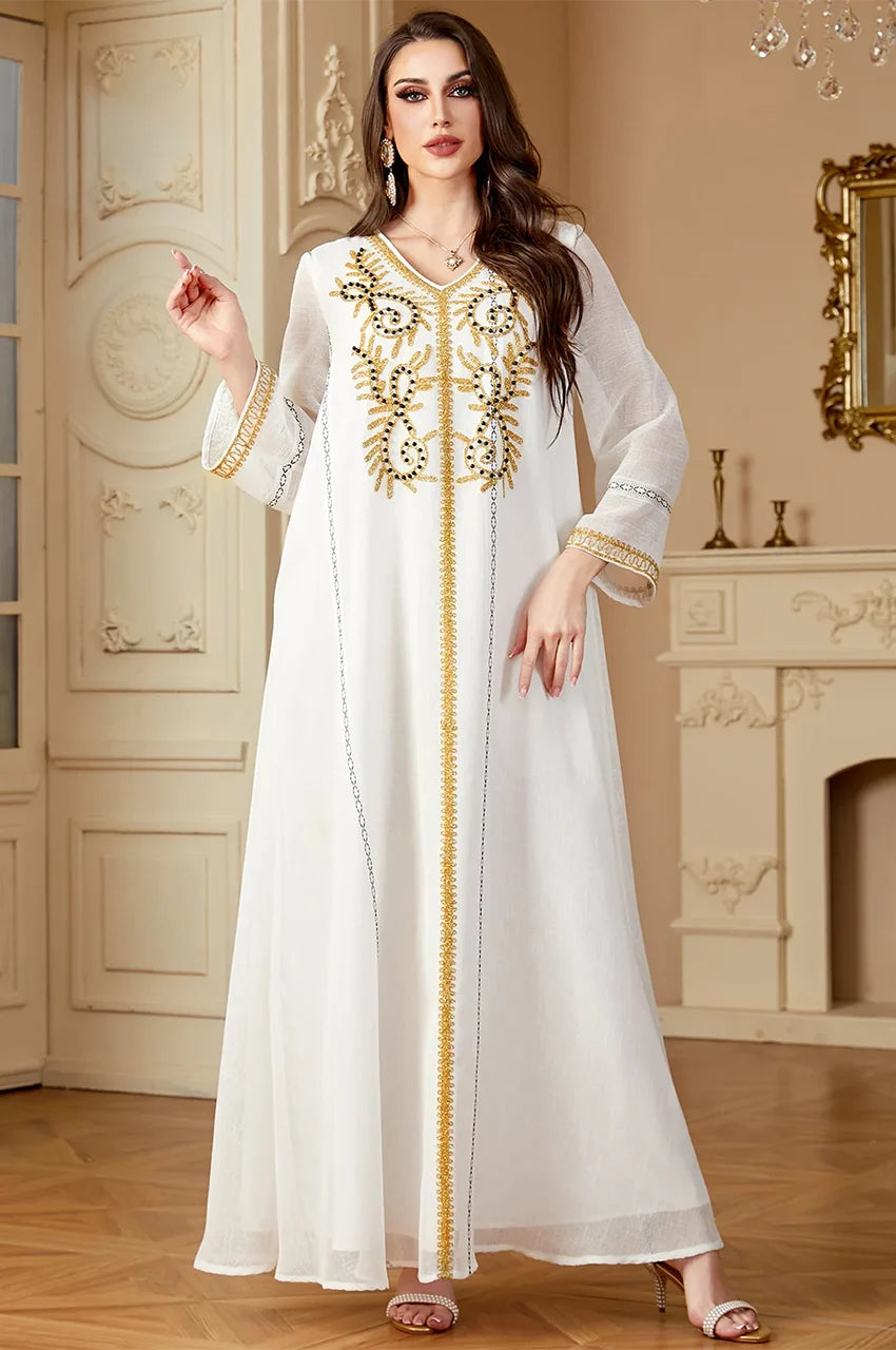 Full length Zaliya White maxi dress with long sleeves and gold cuffs suitable for beach resorts.