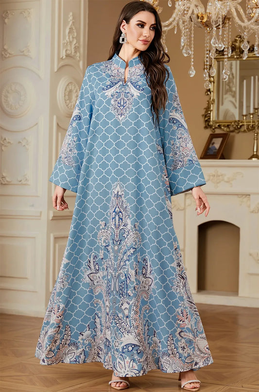 Model wearing the Nirea sky blue paisley print kaftan in a luxury setting, featuring a flowing floor-length bohemian silhouette.