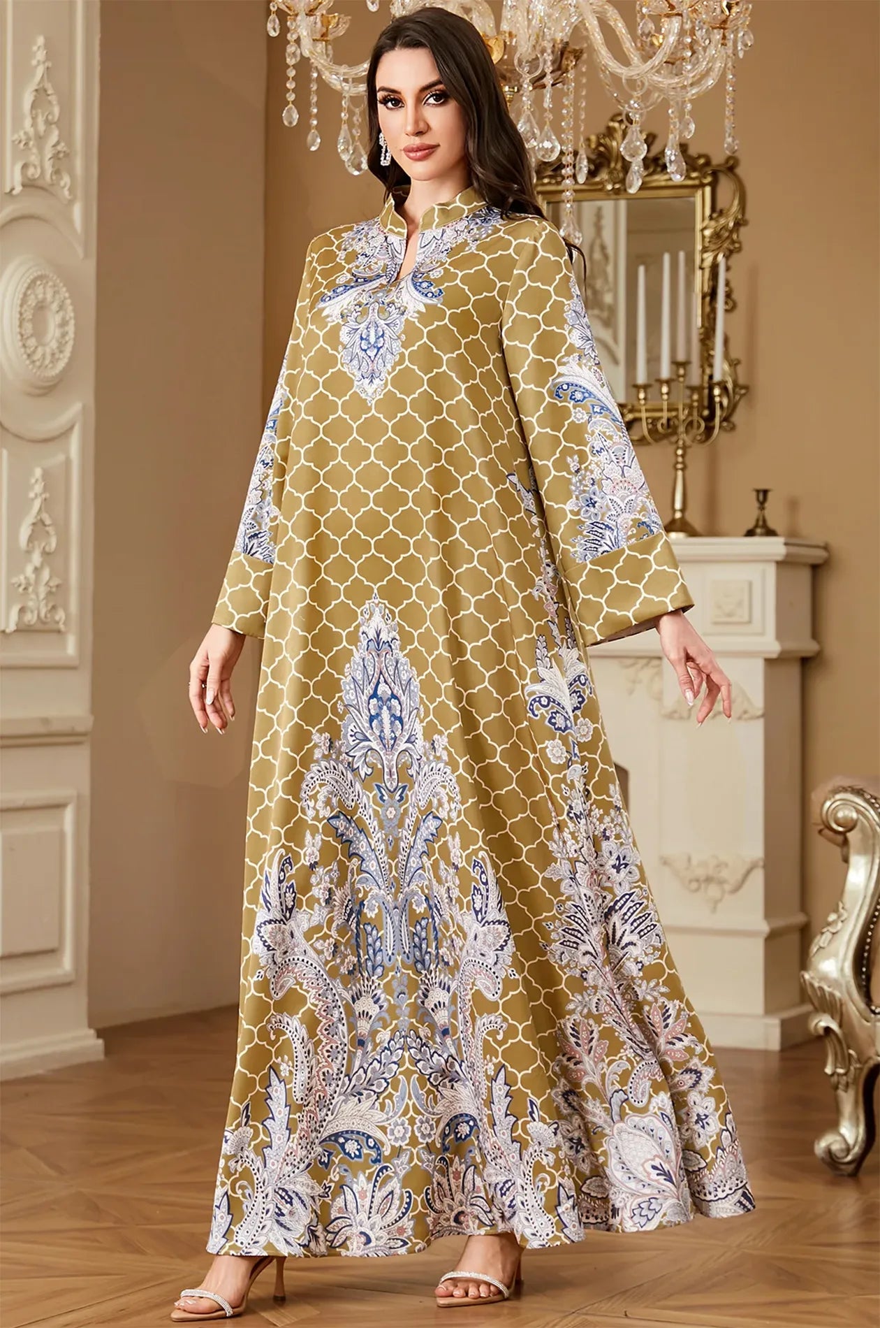 Model wearing the Nirea yellow paisley print kaftan in a luxury interior, showcasing the elegant floor-length silhouette.