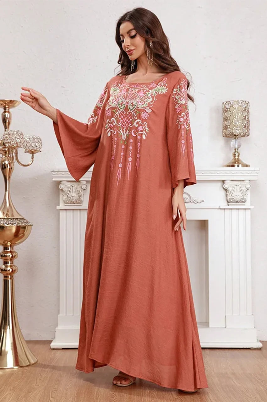 Lifestyle shot of Oraya burnt orange kaftan in an elegant indoor setting.