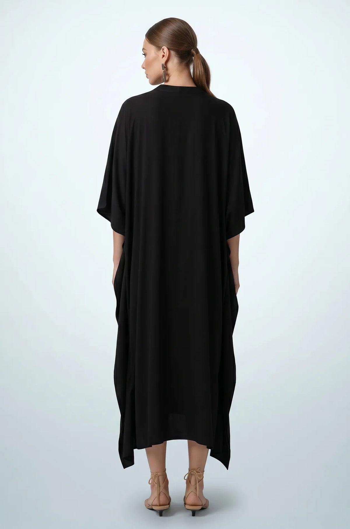 Back view of black plain maxi kaftan with draped hem