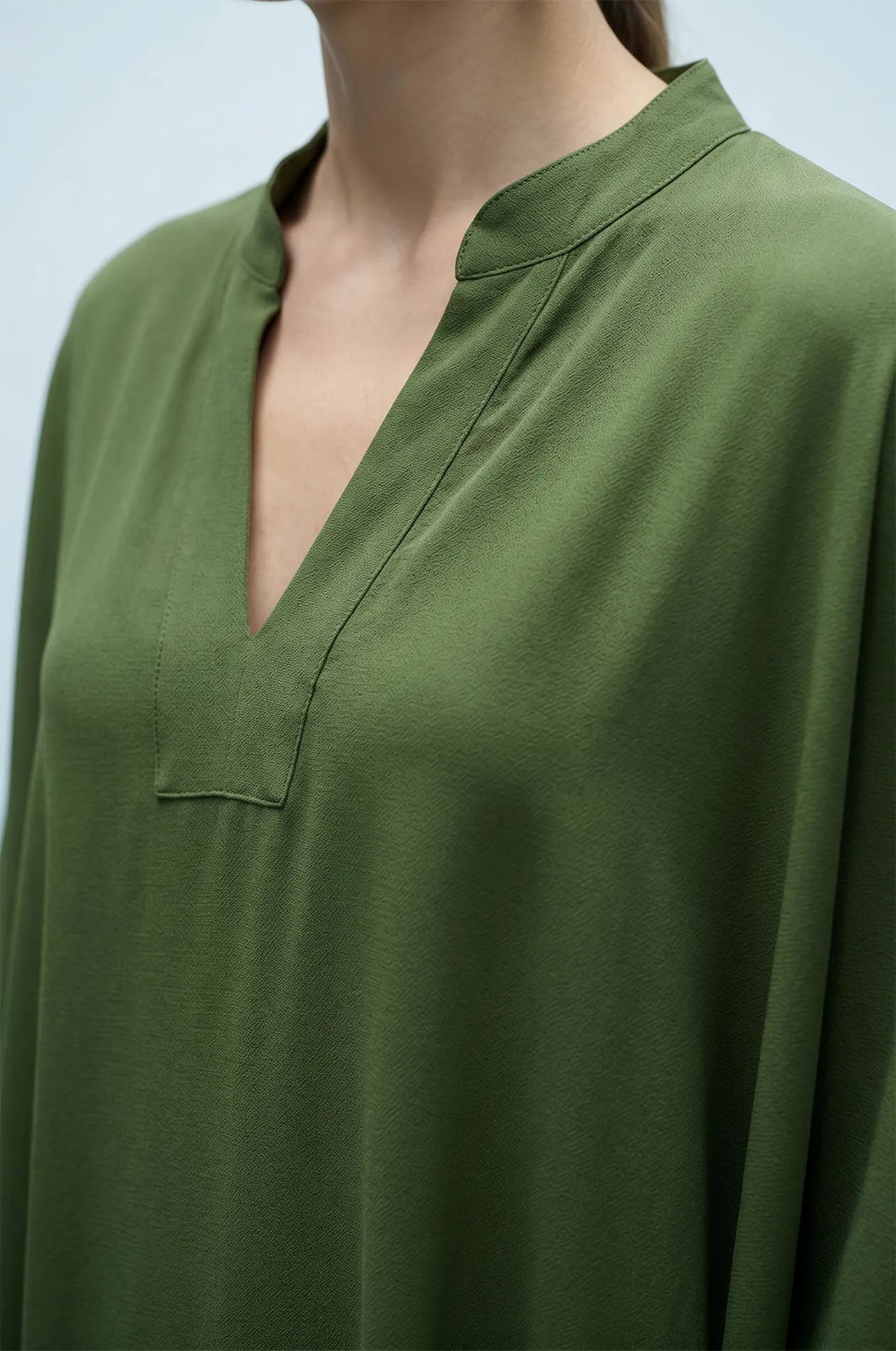 Close-up of olive green plain kaftan split V-neckline detail