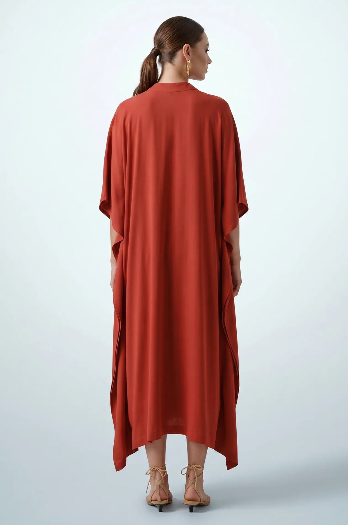 Back view of terracotta orange plain maxi kaftan with draped hem